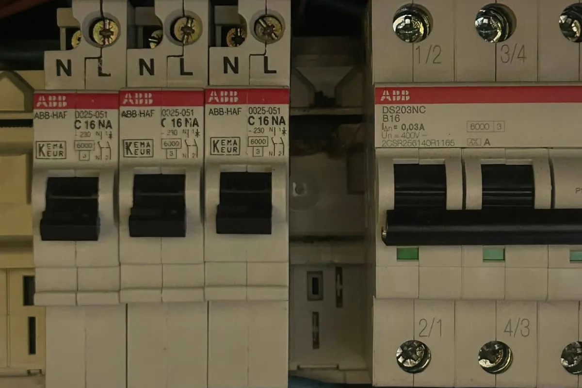 Praktijkfoto: installatieautomaten in een groepenkast, met warmteschade zichtbaar achter de aansluitrail